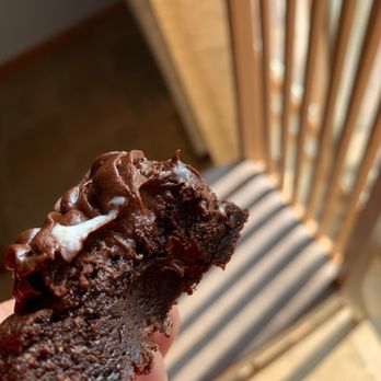 Crumbl - Madison - a hand holding a half eaten chocolate cookie - Bakeries Near Me - Madison, Wisconsin Crumbl - Madison - a hand holding a half eaten chocolate cookie - Bakeries Near Me - Madison, Wisconsin