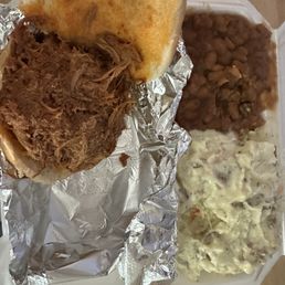 Pulled pork sandwich with potato salad and baked beans