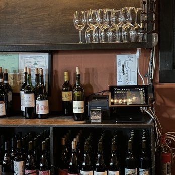 Covell - a shelf of wine bottles and glasses - Wine Bars Near Me - Los Angeles, California