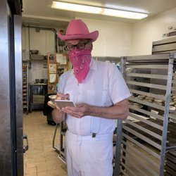 Country Donuts - Part owner since 1980 Scott is ready to take your order for fresh donuts and cinnamon buns! Pink cowboy hat matches COVID 19 bandanna!