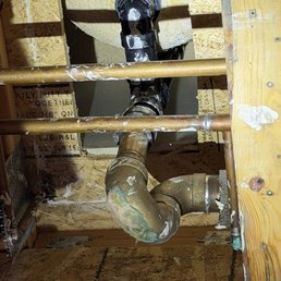 Opened wall to expose pipes and drain. Opened wall to expose pipes and drain.