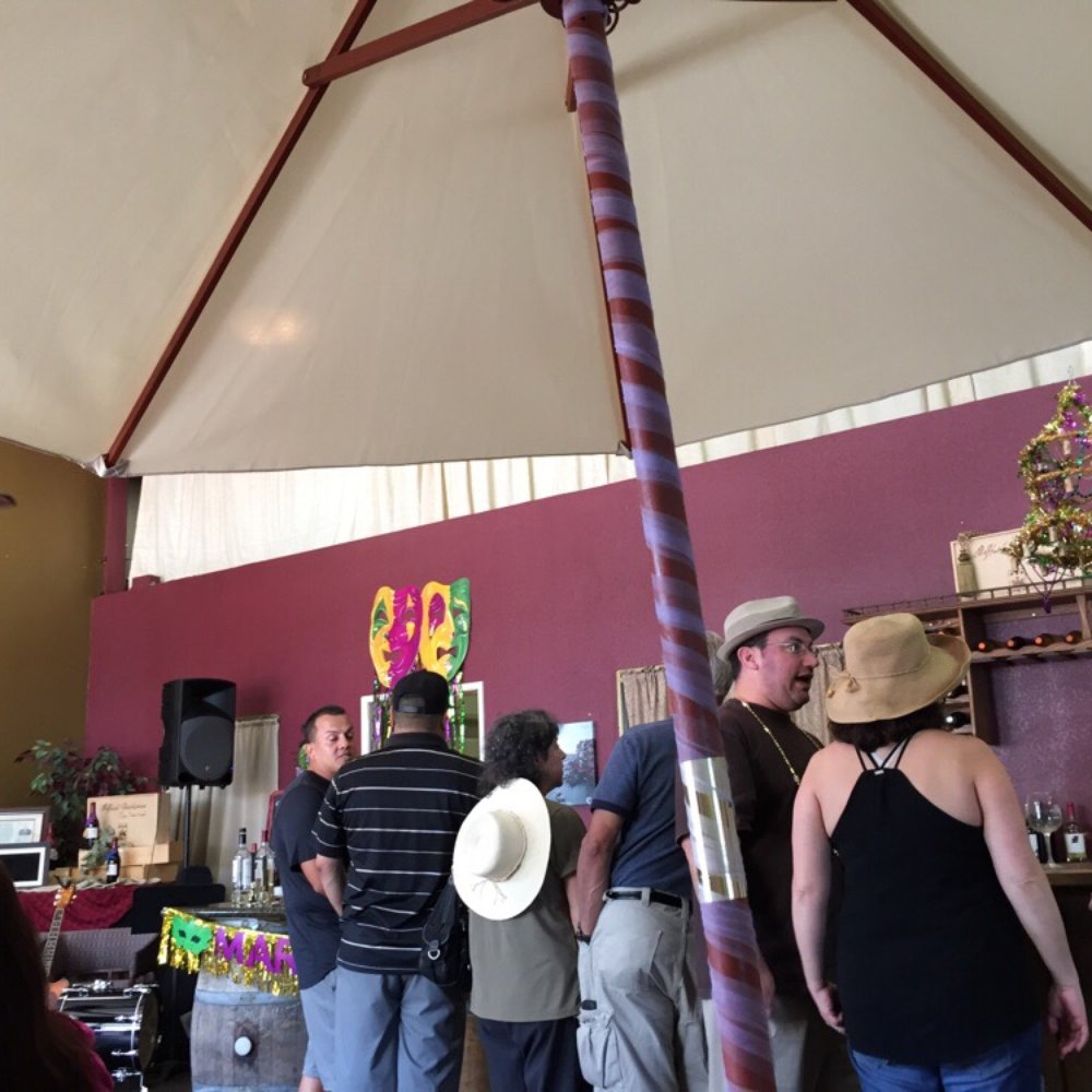 a group of people standing under an umbrella a group of people standing under an umbrella