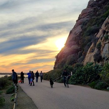 Morro Bay Rock - Sunset behind the Rock , and people walking on the wide walkway around the Rock. - Beaches Near Me - Morro Bay, California Morro Bay Rock - Sunset behind the Rock , and people walking on the wide walkway around the Rock. - Beaches Near Me - Morro Bay, California