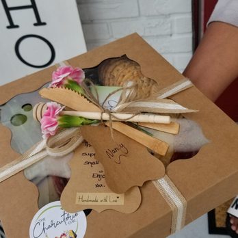 The Charcuterie Chic - a woman holding a box of food - Food Delivery Services Near Me The Charcuterie Chic - a woman holding a box of food - Food Delivery Services Near Me