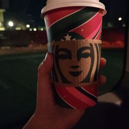 a hand holding a cup of coffee a hand holding a cup of coffee