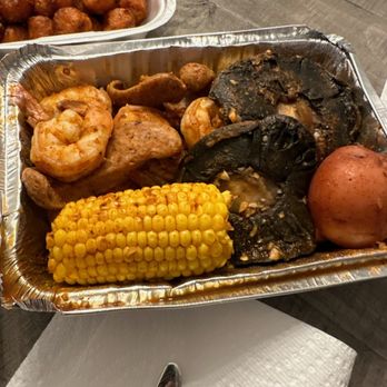 Outcast Seafood - Shrimp, potatoes, corn, mushrooms, alligator sausage. Tots in the background. - Seafood Near Me - Miramar Beach, Florida