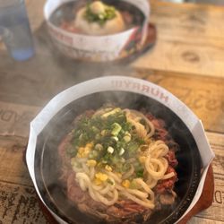 Sizzling Lunch - Garlic steak with udon noodles. The meal in the background is garlic steak and rice.
