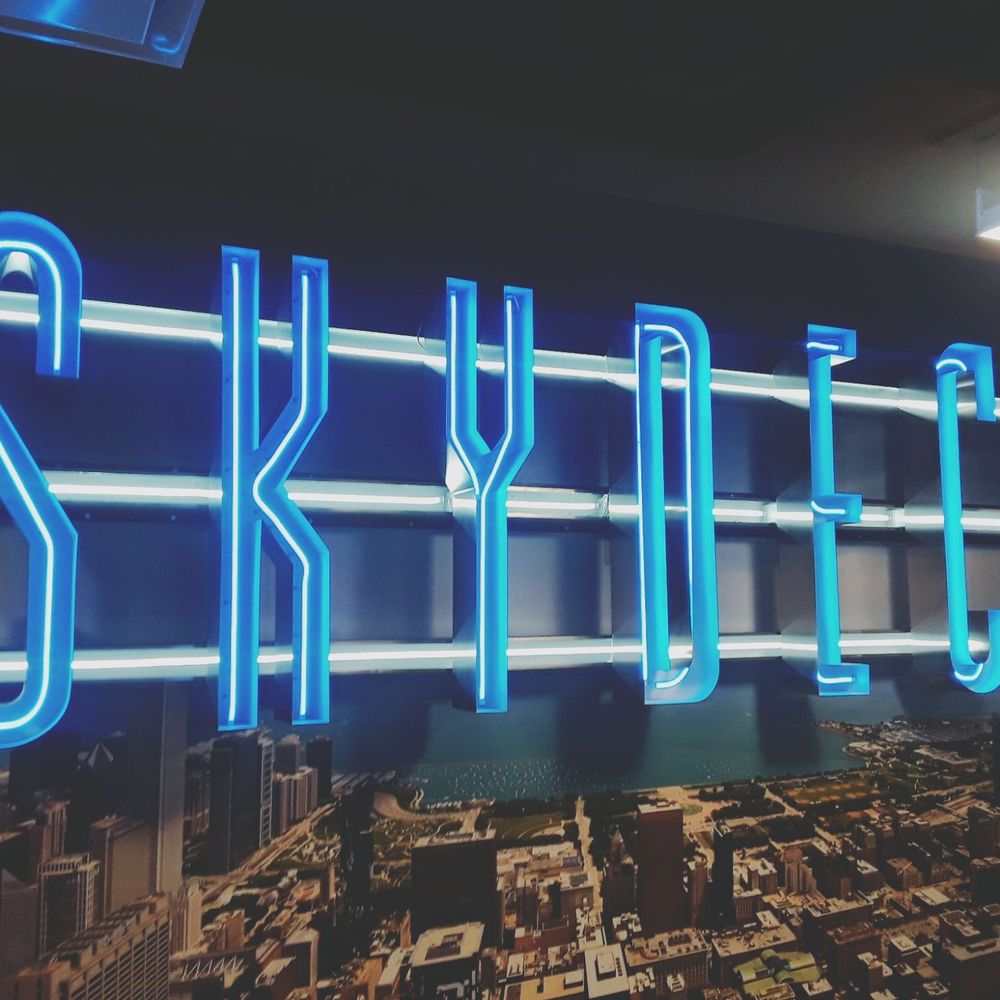 Skydeck - A big blue neon sign greets visitors who wish to journey up to the Sears Tower Skydeck, nearly 1400ft in the air! - Observatories Near Me - Chicago, Illinois Skydeck - A big blue neon sign greets visitors who wish to journey up to the Sears Tower Skydeck, nearly 1400ft in the air! - Observatories Near Me - Chicago, Illinois