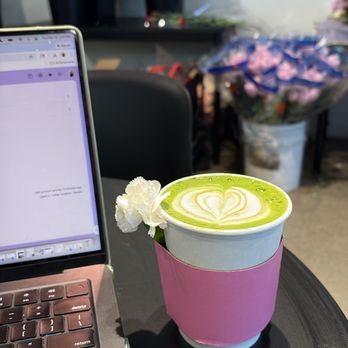 Bloomsgiving - I get their oat milk matcha unsweetened and it's so good. Flower bouquets in the background as they were setting up for Valentine's Day :) - Florists Near Me - Redwood City, California