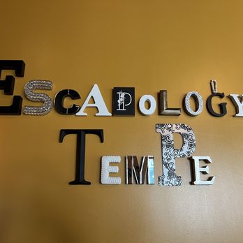 Escapology - 1/13/25 FYI. Cool. - Letters spelling 'Escape Room Time' are mounted on a yellow wall, with each letter having a unique design or material, creating a decorative display. - Escape Games Near Me - Tempe, Arizona