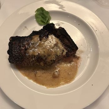 The Capital Grille - Bone-In Kona Crusted Dry Aged NY/KC Strip with Shallot Butter - Steakhouses Near Me - Livonia, Michigan