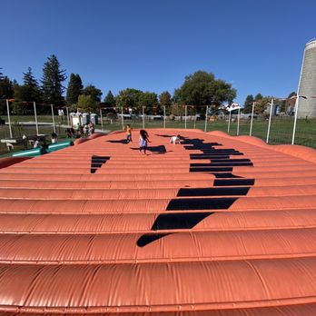 Howell's Greenhouse and Pumpkin Patch - two children playing on an inflatable pumpkin patch - Farmers Market Near Me - Cumming, Iowa