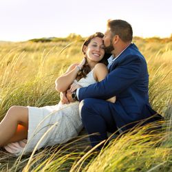 Eye Sugar Photography - Couples photographer engagement photography love photos in Portsmouth New Hampshire. couple sitting in tall grass together hugging