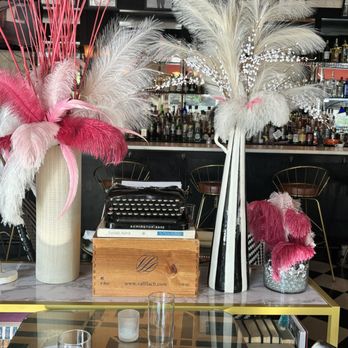 Estragon - Antique typewriter, three decorative pieces sitting on top of a bookshelf. - Tapas Bars Near Me - Boston, Massachusetts