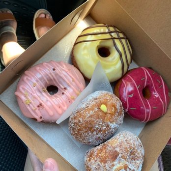 Donut Dynamite - From top clockwise: mango poi, very berry rosemary, malasadas (one filled with lilikoi), pink lemonade - Donuts Near Me - Wailuku, Hawaii Donut Dynamite - From top clockwise: mango poi, very berry rosemary, malasadas (one filled with lilikoi), pink lemonade - Donuts Near Me - Wailuku, Hawaii