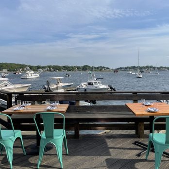 Talise - tables and chairs on a dock with boats in the background - Diners Near Me - Gloucester, Massachusetts