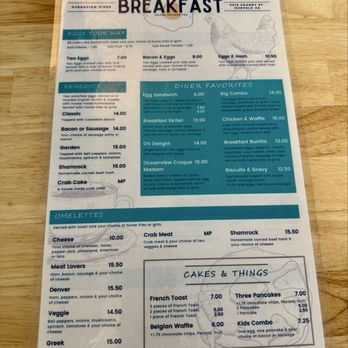 Oceanview Diner - Menu from Oceanview Diner in Norfolk, VA, offering breakfast items including two eggs, Benedict, omelettes, and breakfast specialties like egg sandwich, chicken & waffle, and breakfast burrito. Prices range from $6.00 to $16.00, with options for toast, pancakes, and kids' meals. The menu features a section for cakes and other breakfast items, with detailed descriptions and prices. The menu is printed on a sheet of paper placed on a wooden table. - Breakfast & Brunch Near Me - Norfolk, Virginia