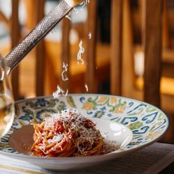 Papaiolo - Freshly grated cheese tops a delicious pasta dish at Papaiolo, complemented by a crisp glass of white wine.