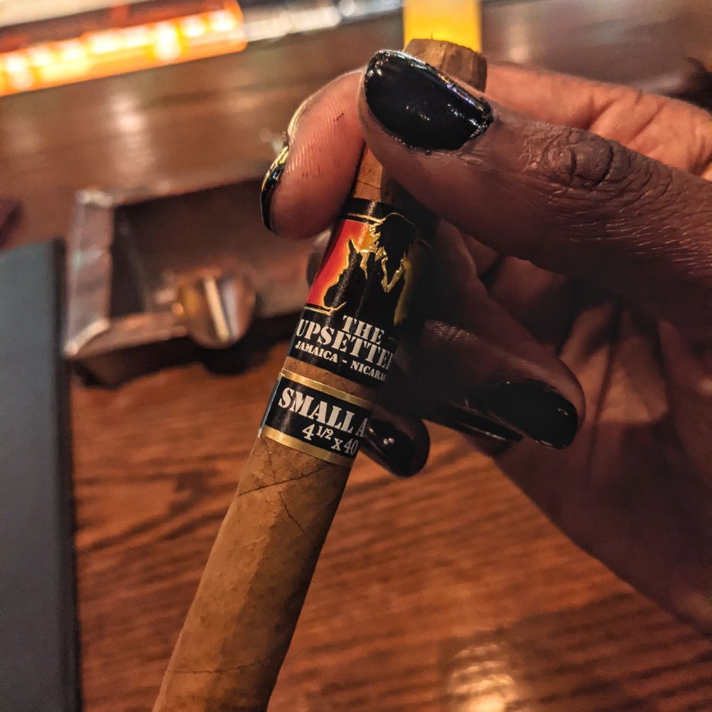 a hand holding a cigar a hand holding a cigar