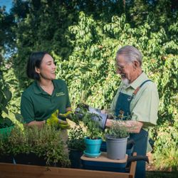 Home Instead - Care pro helping workin the garden with a client