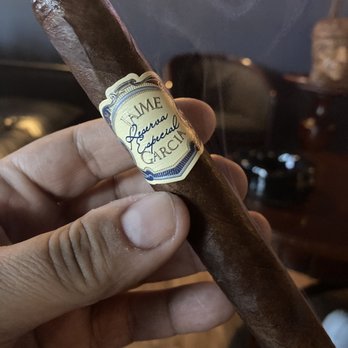 The Cave Cigar Lounge - a hand holding a cigar - Cigar Bars Near Me - Newark, New Jersey The Cave Cigar Lounge - a hand holding a cigar - Cigar Bars Near Me - Newark, New Jersey