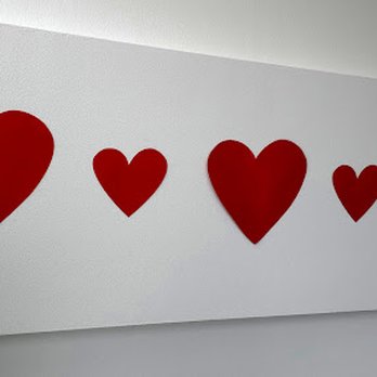 Cielito Lindo Cafe - Five red hearts of different sizes are arranged on a white rectangular panel, likely used as decor. - Coffee & Tea Near Me - Whiting, Indiana