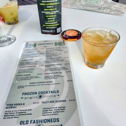 a menu and a drink on a table a menu and a drink on a table