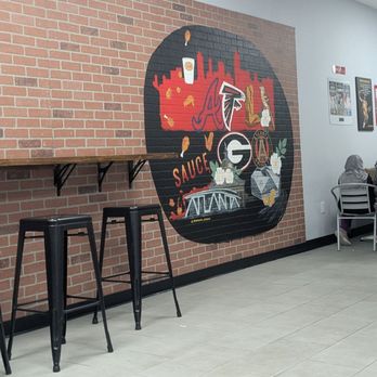 Sauce Wing - A little more table options back there and more fun stuff on the wall. - Cheesesteaks Near Me - Duluth, Georgia