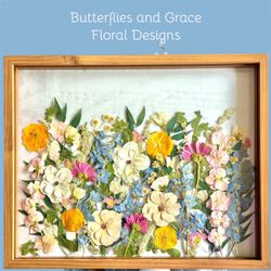 A pressed floral design in a floating glass wood frame.
