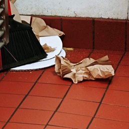 a paper bag and a broom on the floor