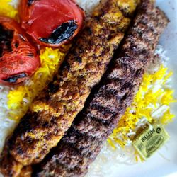Abdullah's Kitchen - Beef and Chicken Koobideh Combo on a bed of rice and grilled tomatoes