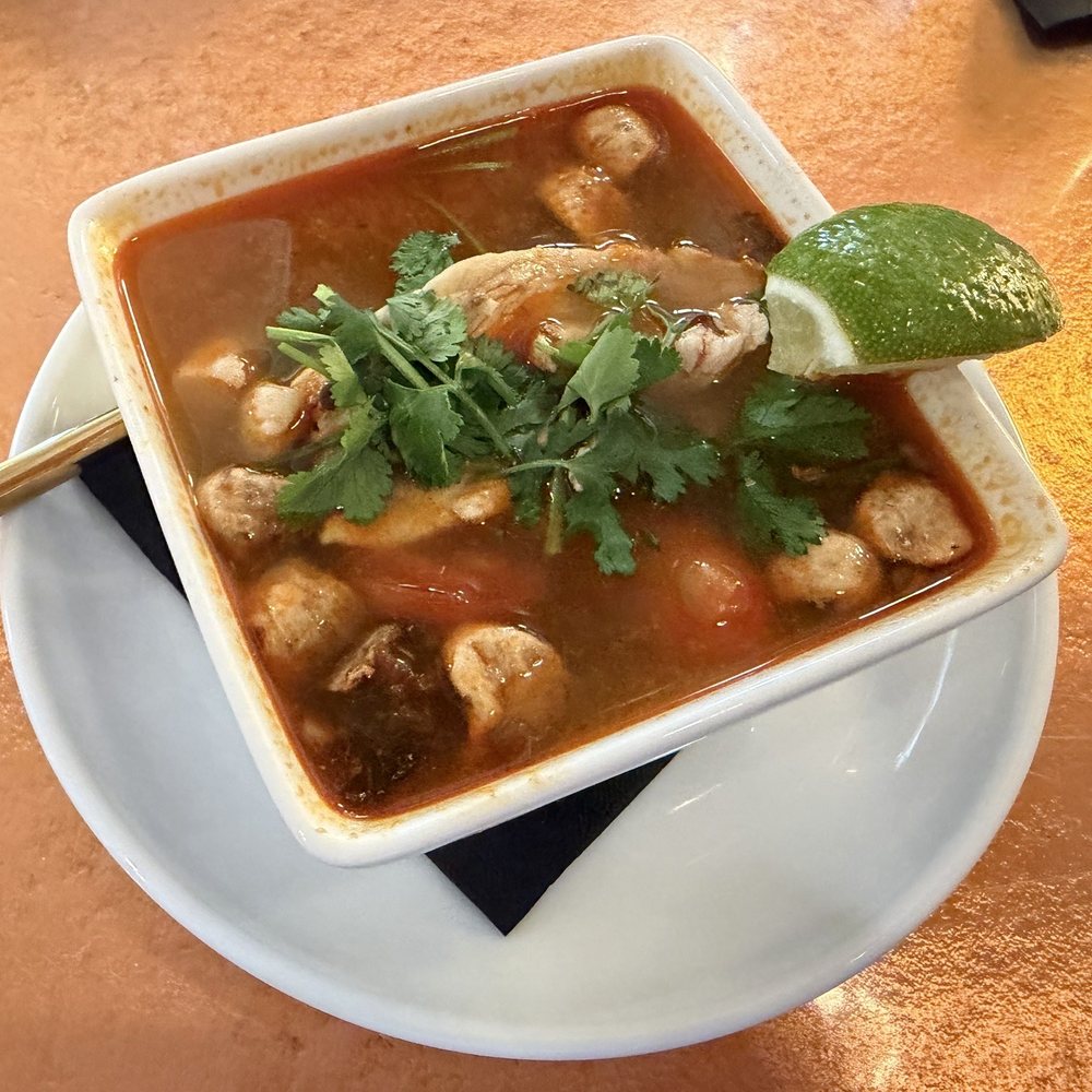 TOM YUM spicy clear soup with mushrooms, cherry tomatoes lemongrass, galangal, and kaffir lime leaves TOM YUM spicy clear soup with mushrooms, cherry tomatoes lemongrass, galangal, and kaffir lime leaves