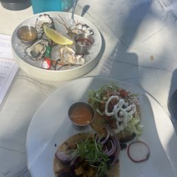 Fresh oysters (back), fish taco (front right), Al pastor taco (front left) Fresh oysters (back), fish taco (front right), Al pastor taco (front left)