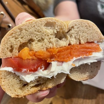Pearl Street Bagels - a person holding a sandwich - Bagels Near Me - Jackson, Wyoming