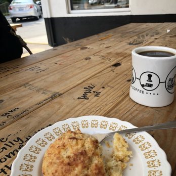 Sunergos Coffee - The cheddar chive biscuit and regular coffee in the background - Coffee & Tea Near Me - Louisville, Kentucky