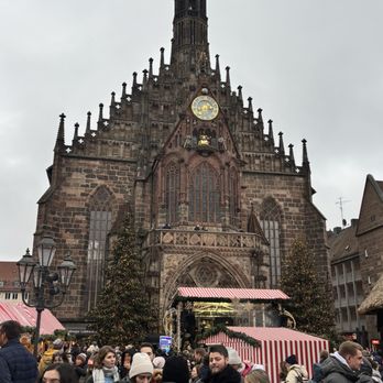 Nürnberger Christkindlesmarkt - Beautiful church backdrop - Christmas Markets Near Me - Nuremberg, BY Nürnberger Christkindlesmarkt - Beautiful church backdrop - Christmas Markets Near Me - Nuremberg, BY