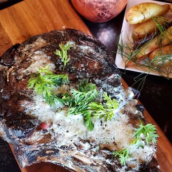 Lewis & Main - Tomahawk sizzled and rested to perfection with a roasted garlic butter reduction. - New American Near Me - Monroe, Washington Lewis & Main - Tomahawk sizzled and rested to perfection with a roasted garlic butter reduction. - New American Near Me - Monroe, Washington