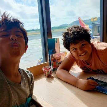 Mea Inu Beach Bar & Grill - My two boys just enjoying watching the planes. Our flight delayed. - American Near Me - Lihue, Hawaii