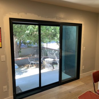 Batchelor Windows & Doors - International Windows Multi-slide door with screens and flush handles installed retro-fit with aluminum trim coil wraps. - Windows Installation Near Me Batchelor Windows & Doors - International Windows Multi-slide door with screens and flush handles installed retro-fit with aluminum trim coil wraps. - Windows Installation Near Me