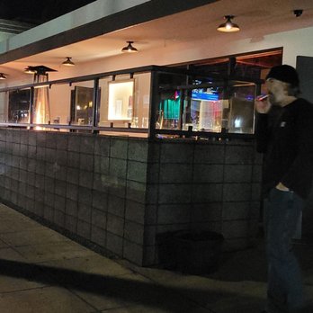 Pour House - a man standing in front of a restaurant - Cocktail Bars Near Me - Oceanside, California