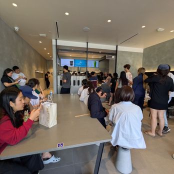 Hey Tea - Interior is bright and modern; gets super crowded - A busy tea shop with many customers seated and standing, featuring a sleek interior and digital menu screens. - Bubble Tea Near Me - Irvine, California
