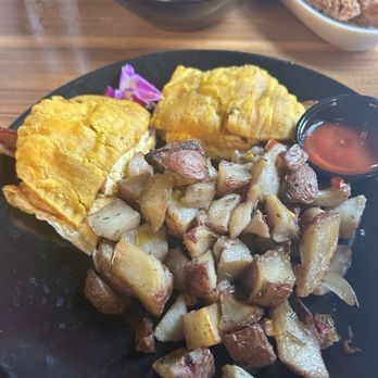Mixxed DC - Beef patty BEC with home fries - A breakfast plate featuring scrambled eggs, diced home fries, and a small container of ketchup, with purple flower garnishes. - Burgers Near Me - Washington, DC, District of Columbia