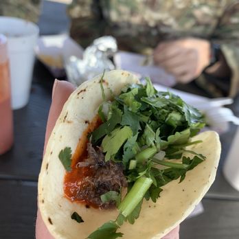 Barbacoa El Primo - a hand holding a taco - Mexican Near Me - Albuquerque, New Mexico