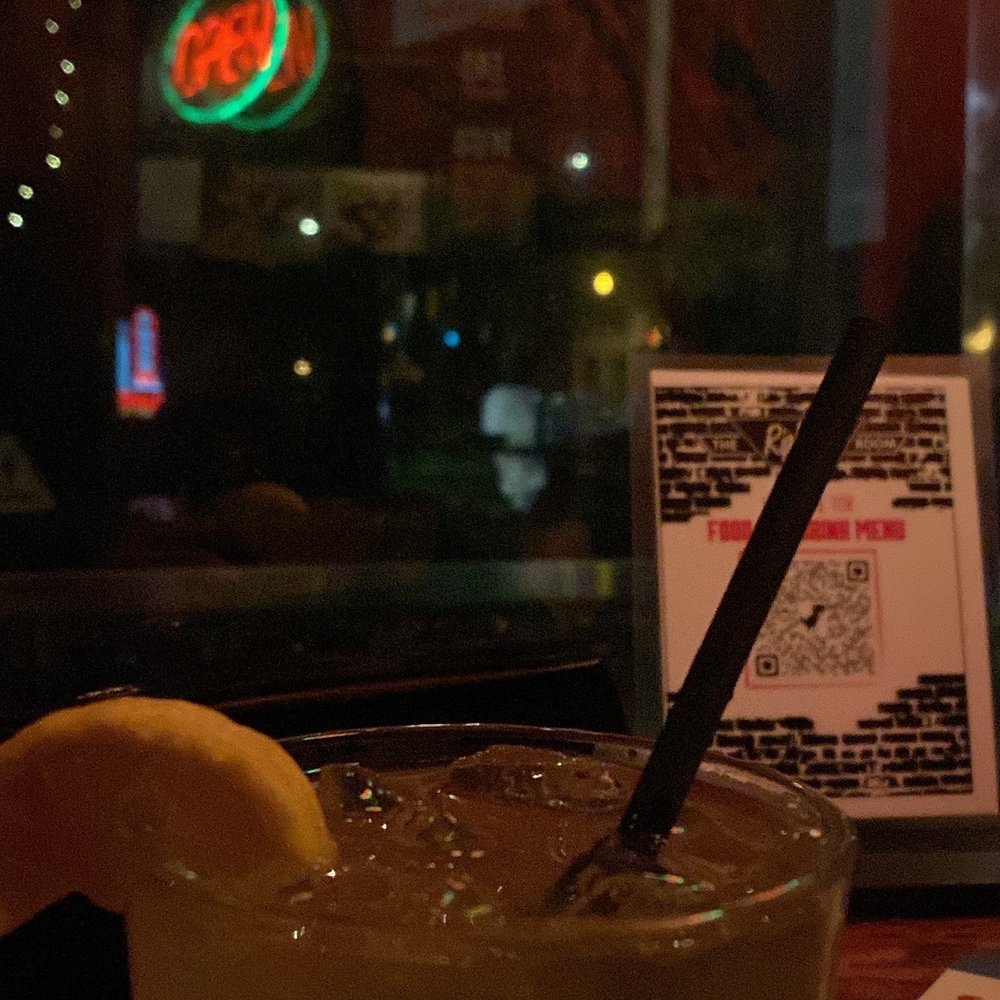 a drink in a glass with a straw and a lemon wedge a drink in a glass with a straw and a lemon wedge