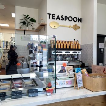 Teaspoon - Berkeley - Inside Teaspoon in Berkeley, the counter displays ice cream flavors, with a glass barrier and a sign showing the business name and logo. The decor includes a plant and shelves. - Bubble Tea Near Me - Berkeley, California
