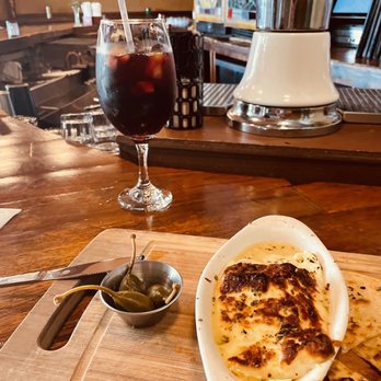 Santiago's Bodega - Saganaki (cheese on fire served with pita bread) and red sangria - Tapas Bars Near Me - Orlando, Florida Santiago's Bodega - Saganaki (cheese on fire served with pita bread) and red sangria - Tapas Bars Near Me - Orlando, Florida