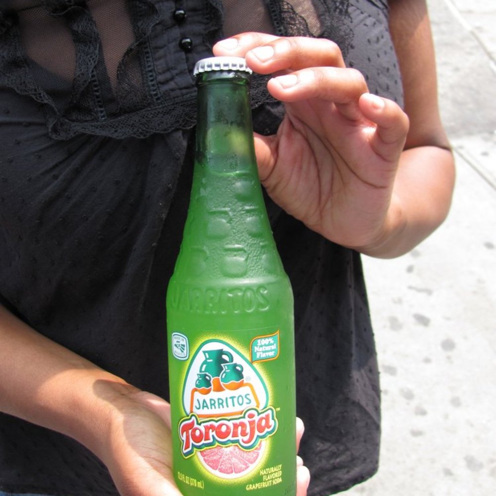 Mi Mexico Lindo Tacos - a woman holding a bottle of drink - Mexican Near Me - Jackson Heights, New York Mi Mexico Lindo Tacos - a woman holding a bottle of drink - Mexican Near Me - Jackson Heights, New York