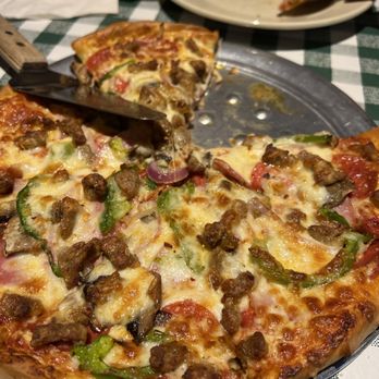Peppers Pizzeria - a pizza with a slice taken out of it - Pizza Near Me - Houma, Louisiana Peppers Pizzeria - a pizza with a slice taken out of it - Pizza Near Me - Houma, Louisiana