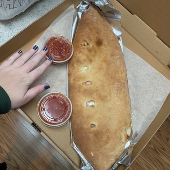 Seppe's Pizza Junction - Large ham and cheese calzone (hand for reference) - Pizza Near Me - Enola, Pennsylvania