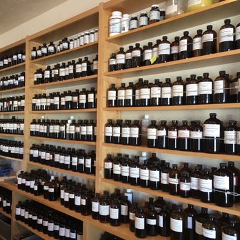 Five Flavors Herbs - a man standing in front of a wall of bottles - Traditional Chinese Medicine Near Me - Grass Valley, California